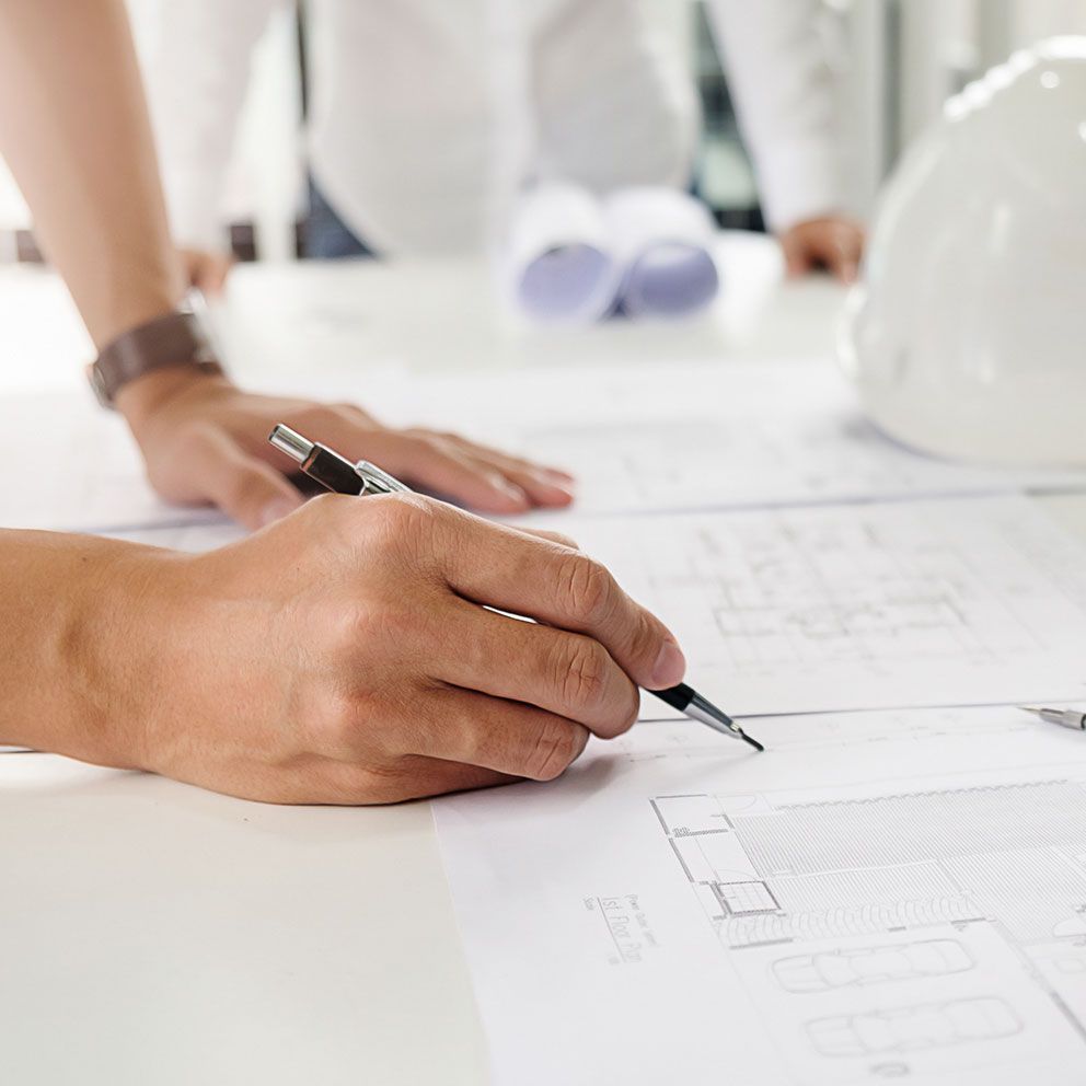 Hand mit Stift skizziert in einen Bauplan