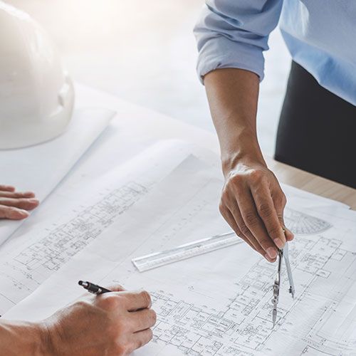 Zwei Personen skizieren in einen Bauplan